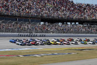 Driver Christopher Bell (20) leads the field to start a NASCAR Cup Series auto race Sunday, Oct. 2, 2022, in Talladega, Ala. (AP Photo/Butch Dill)