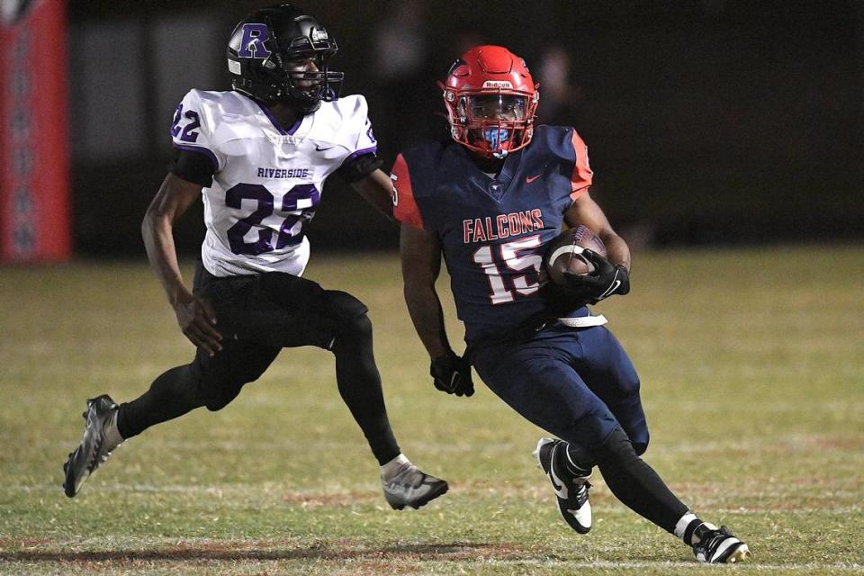 Jordan running back Amareon Blue (15) runs for yardage ahead of Riverside’s Roderick Ross (22) during the first half. The Riverside Pirates and the Jordan Falcons met in a conference football game in Durham, N.C. on October 13, 2023.