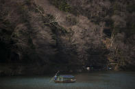 A boatman glides his boat across the river in the Arashiyama district of Kyoto, Japan, March 18, 2020. Widening travel restrictions and closures of most tourism and entertainment venues have gutted the tourism industry in many parts of the world, as well as in Japan. (AP Photo/Jae C. Hong)