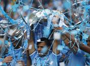 Manchester City's Sergio Aguero celebrates with the English Premier League trophy following their soccer match against West Ham United at the Etihad Stadium in Manchester, northern England May 11, 2014. REUTERS/Darren Staples (BRITAIN - Tags: SPORT SOCCER) FOR EDITORIAL USE ONLY. NOT FOR SALE FOR MARKETING OR ADVERTISING CAMPAIGNS. NO USE WITH UNAUTHORIZED AUDIO, VIDEO, DATA, FIXTURE LISTS, CLUB/LEAGUE LOGOS OR "LIVE" SERVICES. ONLINE IN-MATCH USE LIMITED TO 45 IMAGES, NO VIDEO EMULATION. NO USE IN BETTING, GAMES OR SINGLE CLUB/LEAGUE/PLAYER PUBLICATIONS