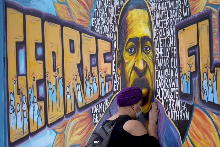 Damarra Atkins paid her respects to George Floyd at a mural at George Floyd Square, Friday, April 23, 2021, in Minneapolis. (AP Photo/Julio Cortez)