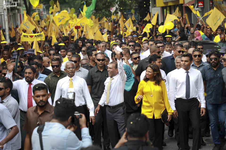 Maldives’ former president Mohamed Nasheed, center, waves to the public in Male, Maldives, Thursday, Nov.1, 2018. Nasheed, the first democratically elected president of the Maldives returned home Thursday after more than two years in exile to escape a long prison term. President elect Ibrahim Mohamed Solih is on his right. (AP Photo/Mohamed Sharuhaan)