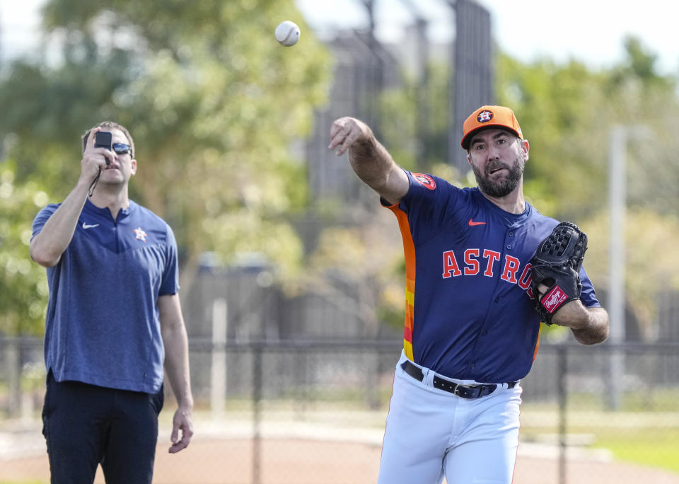 FILE - Houston Astros pitcher Justin Verlander (35) warms up as head athletic trainer Jeremiah Randall observes during spring training baseball workouts, Thursday, Feb. 15, 2024, in West Palm Beach, Fla. There is a bridge that runs from Tommy John and Dr. Frank Jobe in 1974, all the way to Shohei Ohtani, Justin Verlander and Bryce Harper. (Karen Warren/Houston Chronicle via AP, File)