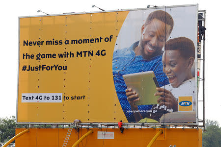 FILE PHOTO: Men work on an advertising billboard for MTN telecommunication company at the central business area in Abuja, Nigeria May 15, 2019. REUTERS/Afolabi Sotunde/File Photo