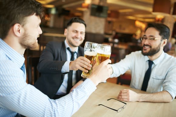 Professionally dressed man clinking beer glasses