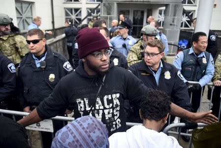 A member of Black Lives Matter tries to keep protesters back from the police line in front of a north Minneapolis police precinct during a protest in response of Sunday's shooting death of Jamar Clark by police officers in Minneapolis, Minnesota, November 18, 2015. REUTERS/Craig Lassig