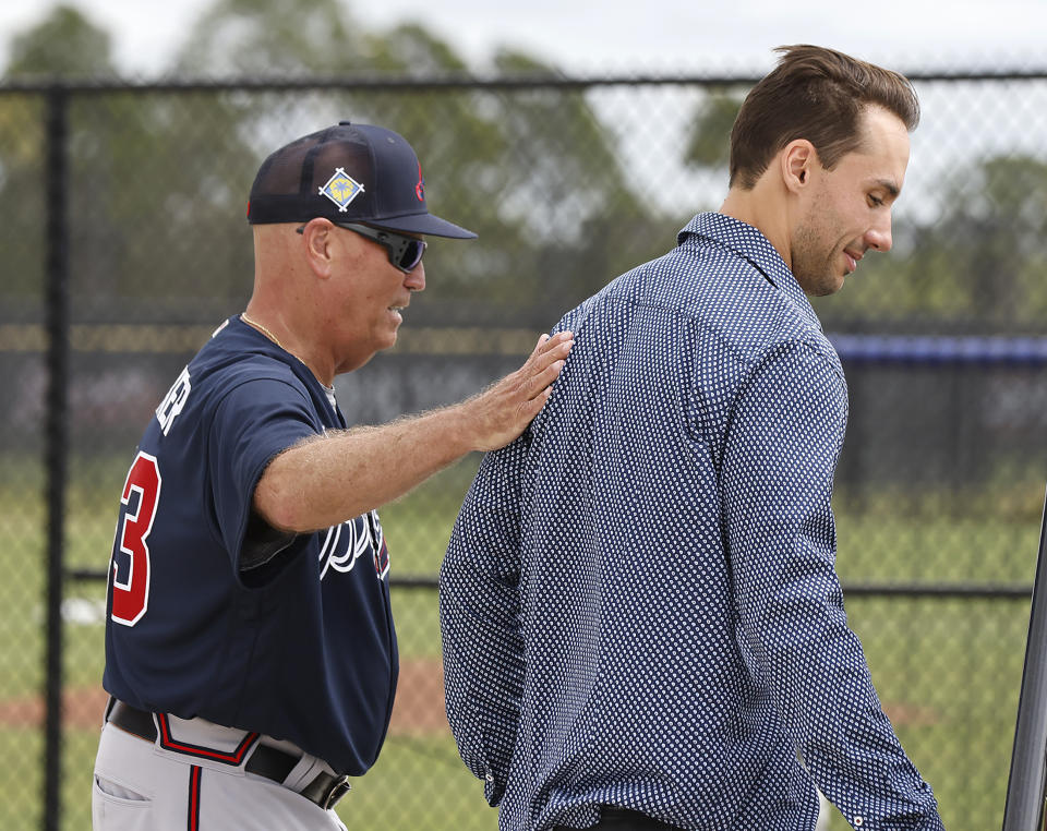 Atlanta Braves manager Brian Snitker gives the team's new first baseman Matt Olson a pat on the back as he arrives at baseball spring training camp in North Port, Fla., Tuesday, March 15, 2022. The Braves signed Olson to a $168 million, eight-year contract. (Curtis ComptonAtlanta Journal-Constitution via AP)