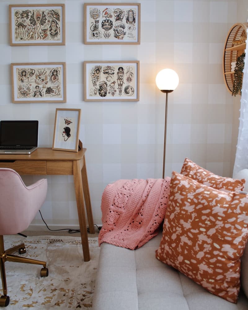 office with beige and white gingham walls, wood desk, and gray sofa