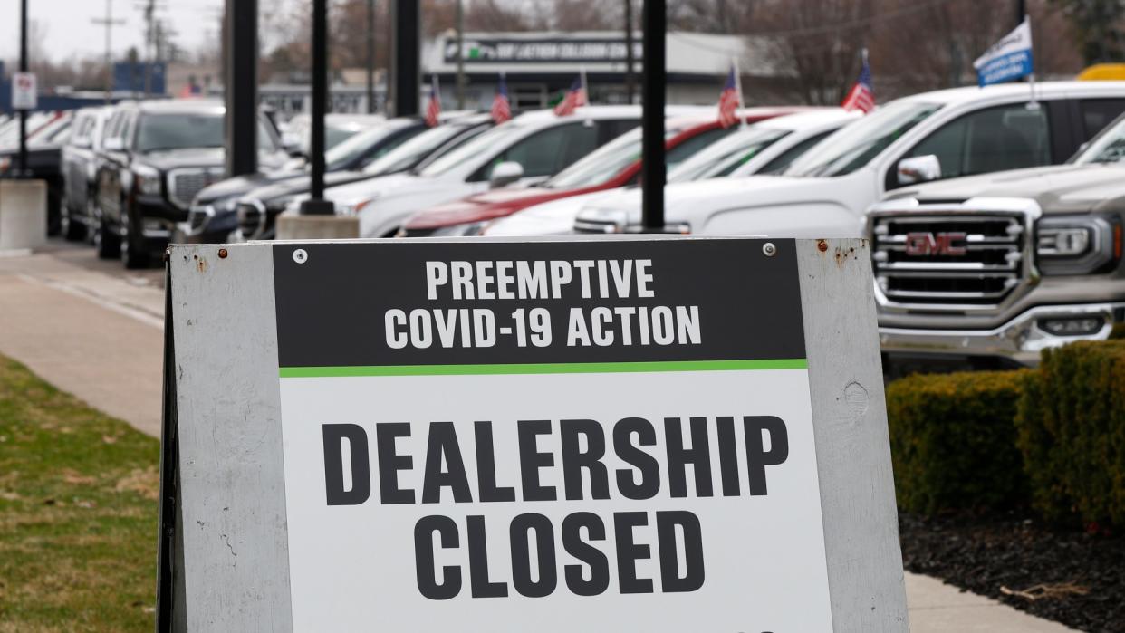 Sign showing an automobile dealership closed as a preemptive COVID-19 action, jn Detroit.