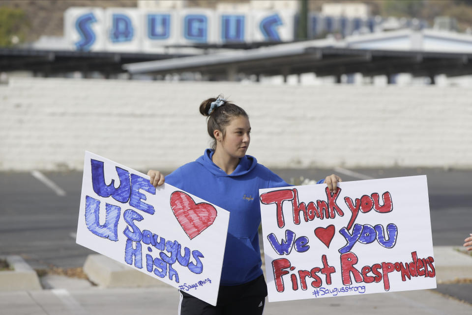 Student Sayla David, 12, holds thank you signs for first responders outside the Saugus High School in Santa Clarita, Calif., Friday, Nov. 15, 2019. A homicide official says that investigators did not find a diary, manifesto or note belonging to the boy who killed two people outside his Southern California high school on his 16th birthday. No motive or rationale has been established yet in the Thursday morning shooting at Saugus High School in the Los Angeles suburb of Santa Clarita. (AP Photo/Damian Dovarganes)