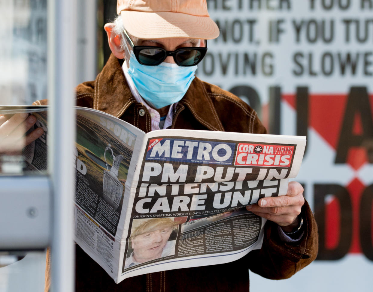 LONDON, ENGLAND - APRIL 07: A man wearing a protective mask reads a story in the Metro newspaper about Boris Johnson while standing outside St Thomas' Hospital in Westminster, where the British Prime Minister has  been transferred to the ICU after showing persistent symptoms of coronavirus (COVID-19) for 10 days, on April 7, 2020 in London, United Kingdom. At 7pm last night an announcement was made that the Prime Minister had been moved to intensive care at St Thomas' Hospital after his symptoms worsened. (Photo by Ollie Millington/Getty Images)