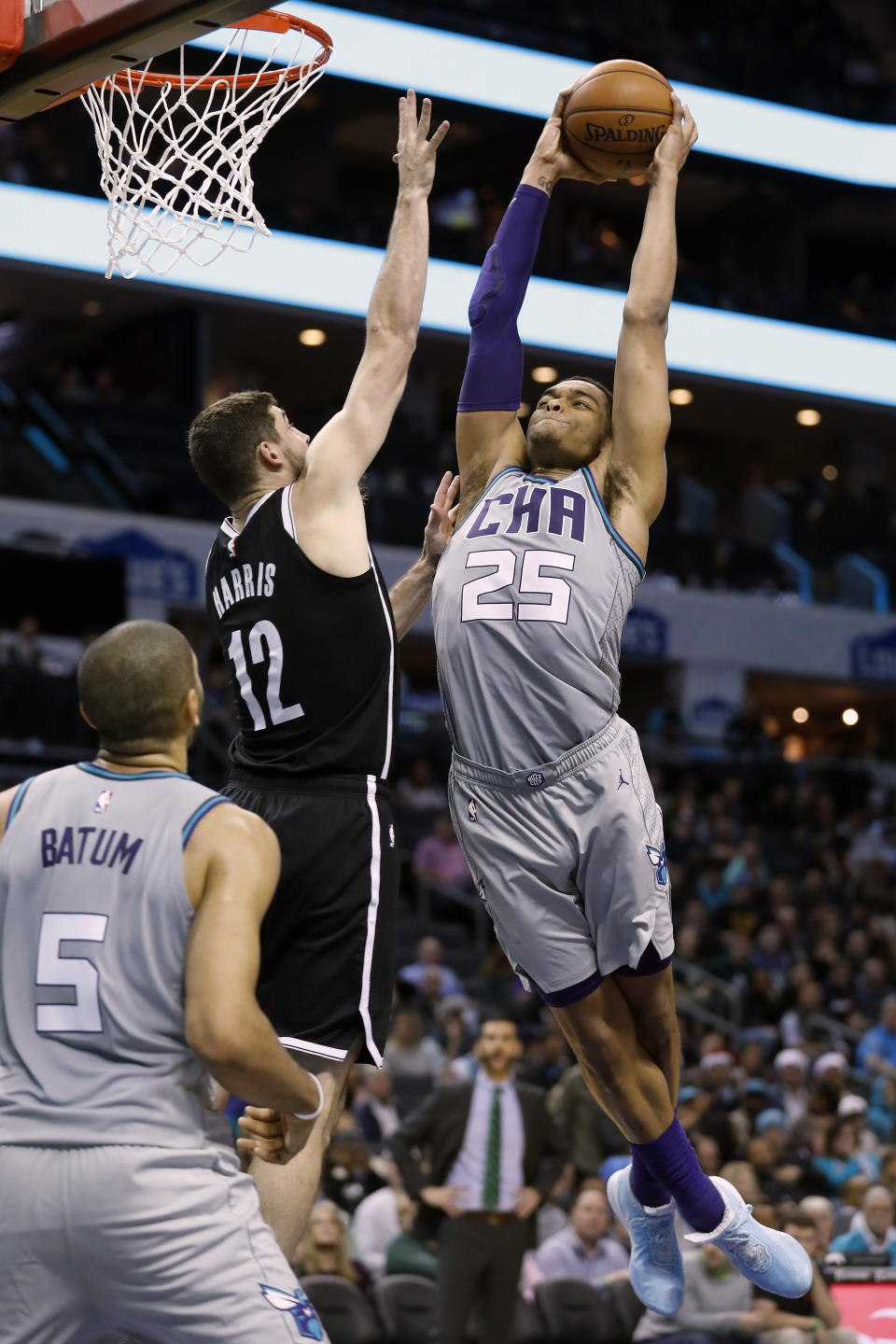 Charlotte Hornets' P.J. Washington (25) goes over Brooklyn Nets' Joe Harris (12) for a dunk during the second half of an NBA basketball game in Charlotte, N.C., Friday, Dec. 6, 2019. The Nets won 111-104. (AP Photo/Bob Leverone)