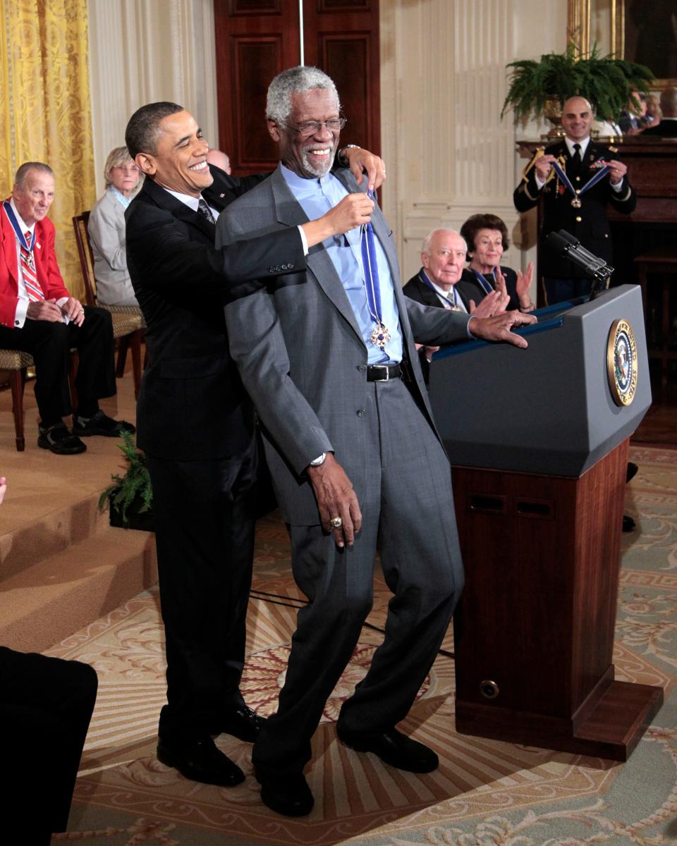 President Barack Obama reaches up to present the Presidential Medal of Freedom to Bill Russell in 2011.