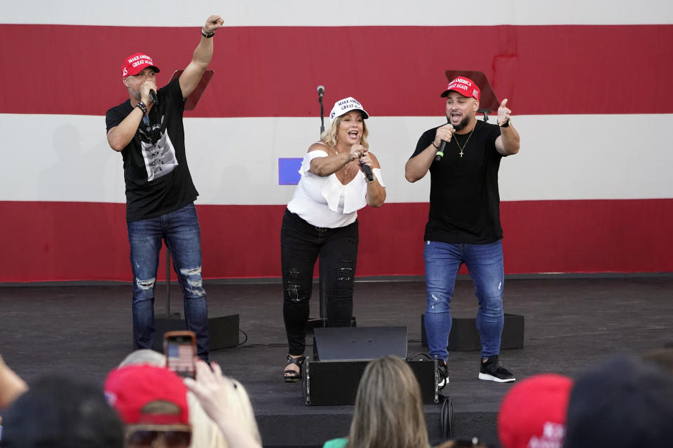 FILE- In this Tuesday, Oct. 27, 2020 file photo, members of the Cuban musical group Los 3 de La Habana, German Pinelli, left, Ana Paez, center, and Tirso Luis, right, sing during a "Make America Great Again!" event with Ivanka Trump at Bayfront Park Amphitheater, in Miami. Florida's Cuban American voters remain a bright spot in Trump's effort to retain his winning coalition from 2016. Polls show his strong support from these key voters may even be growing to include the younger Cuban Americans that Democrats once considered their best hope of breaking the GOP's hold. The musicians say Trump’s economic and foreign policies have been his main achievements. (AP Photo/Wilfredo Lee, File)