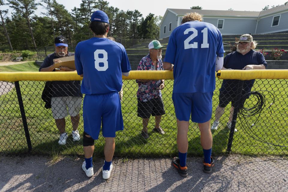 Chatham Anglers' Zach MacDonald (8) and Gabe Davis (21) sign autographs before a Cape Cod League baseball game against the Bourne Braves, Wednesday, July 12, 2023, in Bourne, Mass. For 100 years, the Cape Cod League has given top college players the opportunity to hone their skills and show off for scouts while facing other top talent from around the country. (AP Photo/Michael Dwyer)