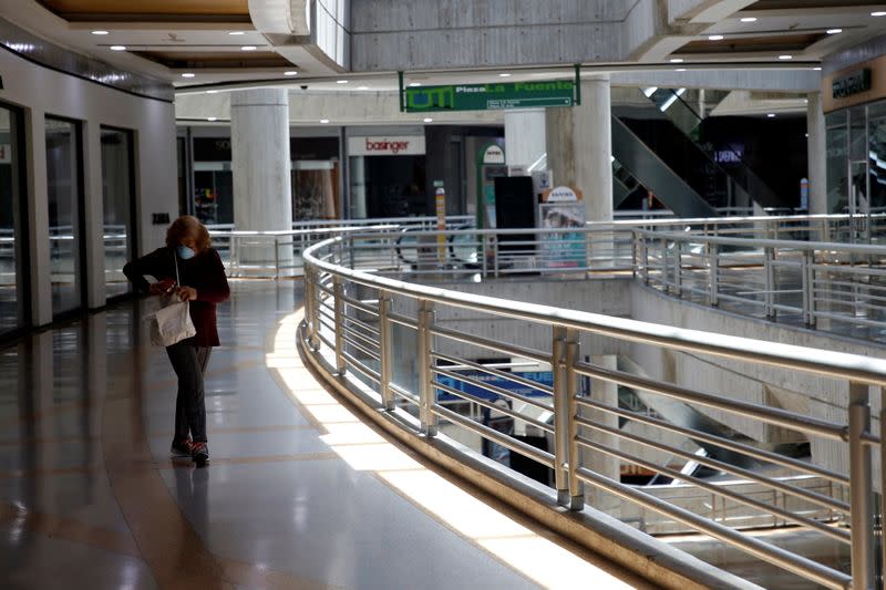 A woman wearing a protective mask walks in a mall during the quarantine in response to the spreading of coronavirus disease (COVID-19) in Caracas