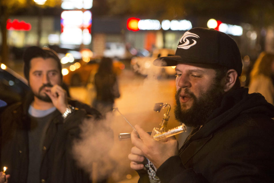 FILE - In this Oct. 17, 2018, file photo, people smoke cannabis on the street in Toronto. China has become the latest Asian country to warn its citizens in Canada about marijuana after it was legalized for recreational use there. (Chris Young/The Canadian Press via AP, File)