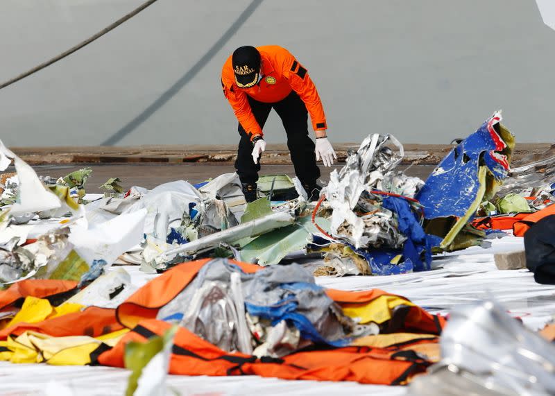 A member of Indonesia's rescue personnel observes the debris of Sriwijaya Air flight SJ 182, which crashed into the Java Sea, at the last day of the search and rescue operation, at Tanjung Priok port in Jakarta