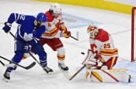 Calgary Flames' goaltender Jacob Markstrom (25) makes a save as Toronto Maple Leafs' Alex Galchenyuk (12) and Rasmus Andersson (4) battle during the second period of an NHL hockey game Tuesday, April 13, 2021 in Toronto. (Frank Gunn/Canadian Press via AP)