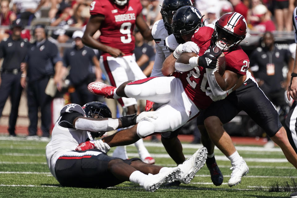 Indiana's Tim Baldwin Jr. (20) is tackled by Cincinnati's Myjai Sanders and Tyler Scott Ty Van Fossen (13) during the second half of an NCAA college football game, Saturday, Sept. 18, 2021, in Bloomington, Ind. Cincinnati won 38-24. (AP Photo/Darron Cummings)