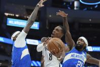 Brooklyn Nets' Lonnie Walker IV shoots between Milwaukee Bucks' Patrick Beverley and Bobby Portis during the first half of an NBA basketball game Thursday, March 21, 2024, in Milwaukee. (AP Photo/Morry Gash)