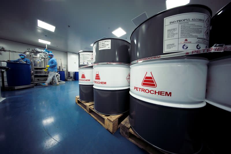 Employees mix chemicals into a steamer tank to make hand-sanitizers at Dhaman Medical Company, following the outbreak of the coronavirus disease (COVID-19), in Hidd