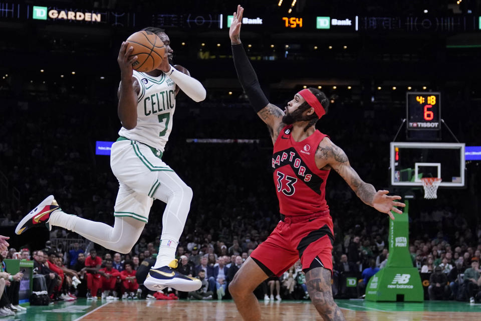 Boston Celtics guard Jaylen Brown (7) looks to pass while pressured by Toronto Raptors guard Gary Trent Jr. (33) during the first half of an NBA preseason basketball game, Wednesday, Oct. 5, 2022, in Boston. (AP Photo/Charles Krupa)