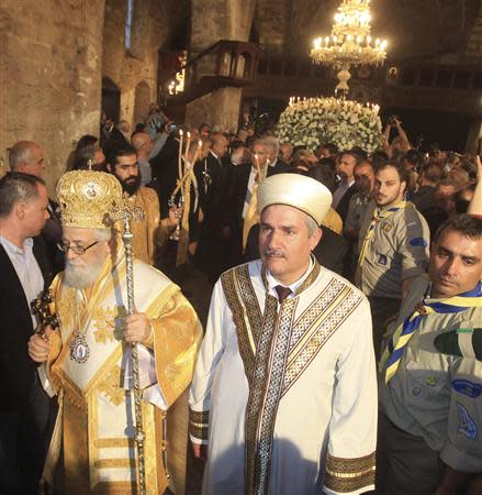 A Greek Orthodox bishop and an Islamic cleric attend a Good Friday liturgy at the Church of St. George Exorinos in Famagusta, northern Cyprus, April 18, 2014. REUTERS/Andreas Manolis