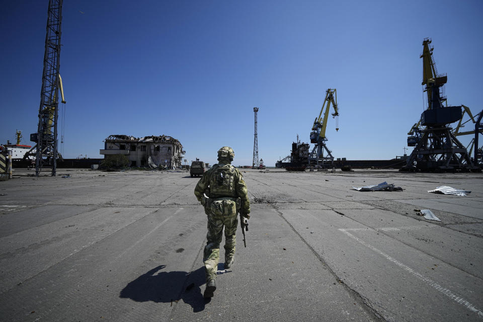 A Russian serviceman walks while guarding an area of the Mariupol Sea Port in Mariupol, in territory under the government of the Donetsk People's Republic, eastern Ukraine, Friday, April 29, 2022. This photo was taken during a trip organized by the Russian Ministry of Defense. (AP Photo)