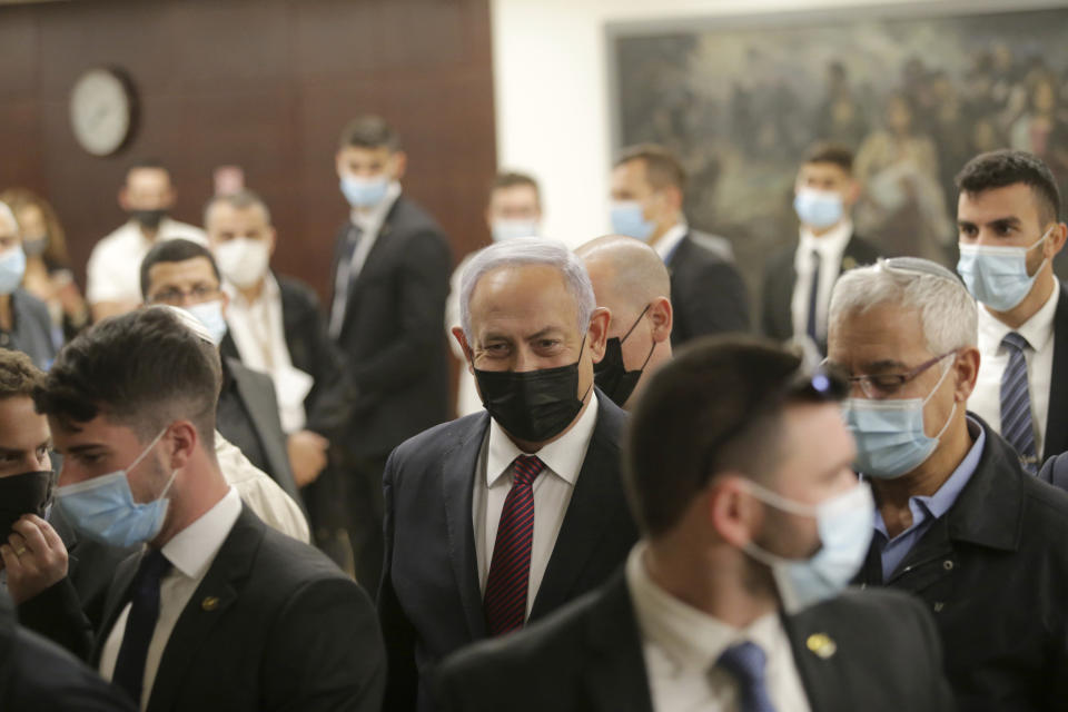 Israeli Prime Minister Benjamin Netanyahu, center, leaves the Israeli Knesset (Parliament) after a vote on the dissolution of the Knesset, in Jerusalem, Wednesday, Dec. 2 2020. The Israeli parliament passed a preliminary proposal to dissolve itself on Wednesday, setting up a possible fourth national election in under two years while the country is in the grip of the coronavirus pandemic. (Alex Kolomoisky/Pool via AP)