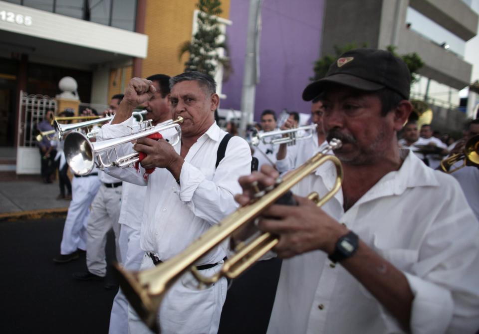 A musician gestures as his brass band plays songs known to be favorites of Joaquin "Chapo" Guzman during a march in Culiacan