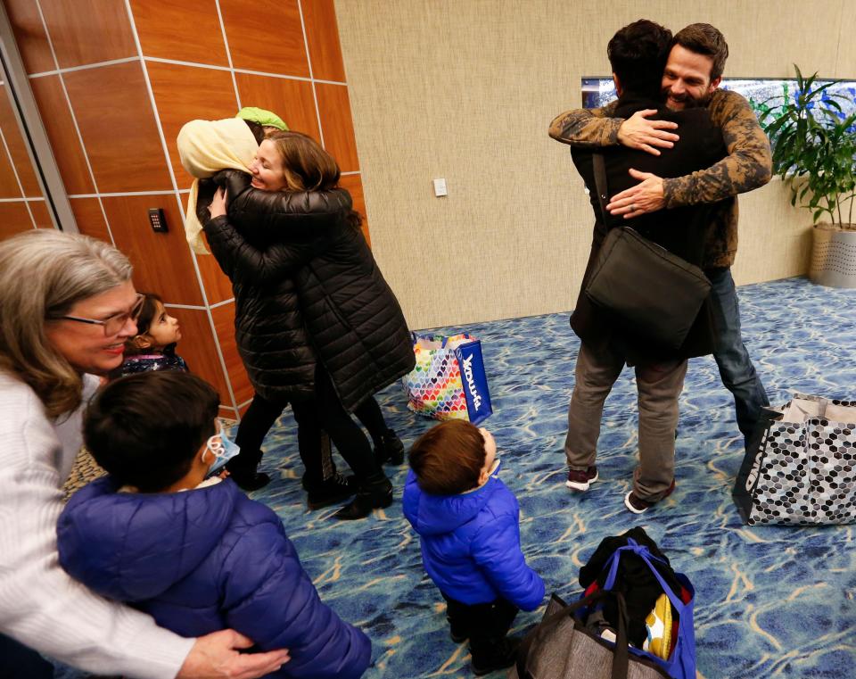 Tommy and Sally Breedlove hug Romal and Farishta Noori as they greet them and their four children at the Springfield-Branson National Airport on Monday, Jan. 10, 2022. Romal Noori, who served as a translator for American troops in Afghanistan, fled the country with his family after the troop withdrawal last year.