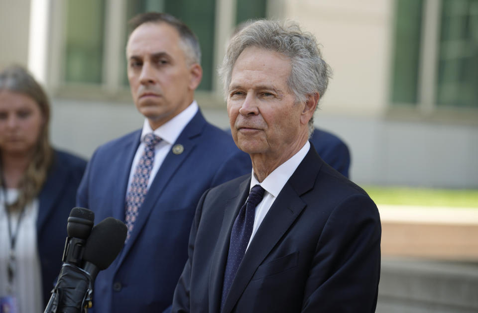 U.S. Attorney for Colorado, Cole Finegan, front, speaks as Mark Michalek, special agent in charge of the FBI bureau in Denver, looks on after a judge handed down a sentence of life in prison and more than $15 million in penalties to Larry Rudolph, the wealthy owner of a Pittsburgh-area dental franchise, for killing his wife at the end of an African safari in Zambia, during a sentencing hearing Monday, Aug. 21, 2023, in the federal courthouse in Denver. (AP Photo/David Zalubowski)