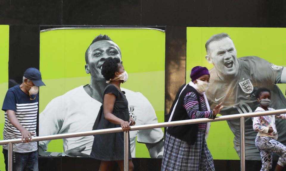 People wearing face masks queue at a South African Social Security Agency (SASSA) to collect their government grant in Cape Town South Africa, Monday, May 11, 2020. South Africa's Western Cape province, which includes the city of Cape Town, has emerged as the country's coronavirus hotspot, accounting for more than half of the nation's confirmed cases, which have gone above 10,000.(AP Photo/Nardus Engelbrecht)