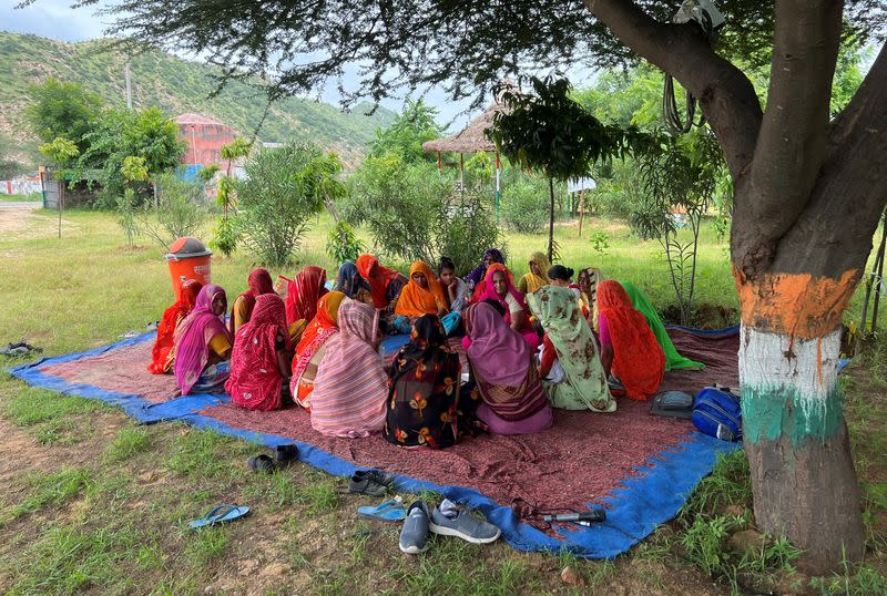 Women sit under a tree as they discuss water issues in Manda Bhopawas village