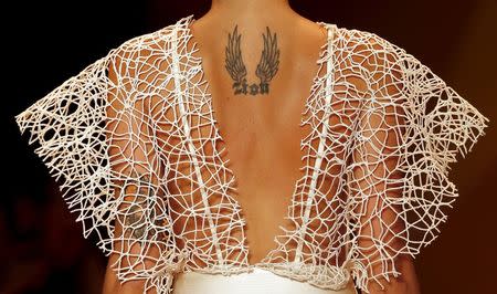 A tattoo is seen on the back of Brazilian top model Isabeli Fontana as she presents a creation from the Agua de Coco Summer 2016 Ready To Wear collection during Sao Paulo Fashion Week in Sao Paulo April 14, 2015. REUTERS/Paulo Whitaker