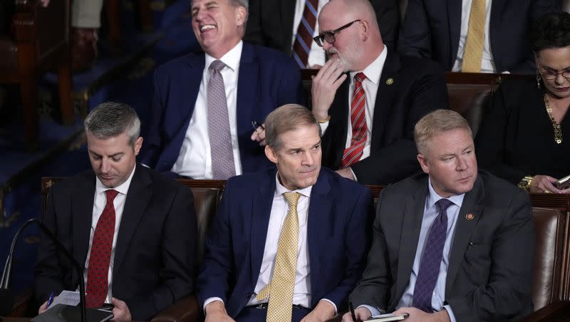 Rep. Jim Jordan, R-Ohio, sits with Rep. Warren Davidson, R-Ohio, right, as Republicans try to elect the Judiciary chairman and a top Donald Trump ally, to be the new House speaker, at the Capitol in Washington, Tuesday, Oct. 17, 2023. At rear, former Speaker Kevin McCarthy, R-Calif., shares a laugh with Rep. Derrick Van Orden, R-Wis.