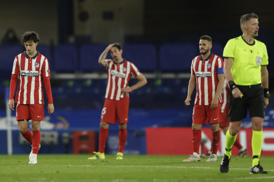 Joao Félix, Stefan Savic y Koke (desde la izquierda) del Atlético de Madrid reaccionan tras el gol de Hakim Ziyech para Chelsea en el duelo de octavos de final de la Liga de Campeones, el miércoles 17 de marzo de 2021. (AP Foto/Matt Dunham)