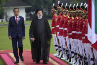 Iran's President Ebrahim Raisi, center, accompanied by Indonesian President Joko Widodo, left, inspects an honor guard upon his arrival at the Presidential Palace in Bogor, West Java, Indonesia, Tuesday, May 23, 2023.(AP Photo/Achmad Ibrahim)