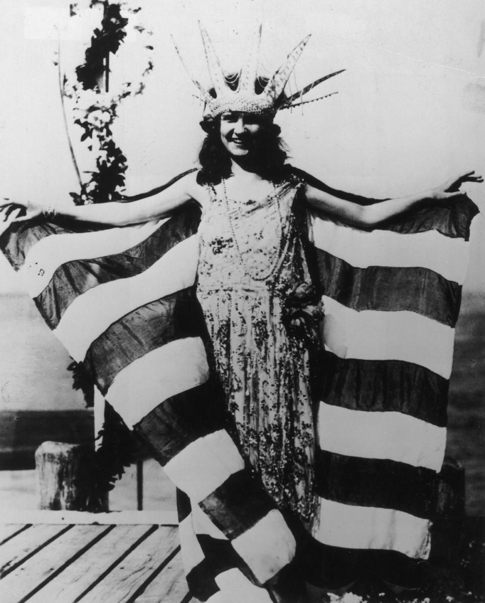 <p>Miss America's evening gown competition has been iconic since the very first pageant. Margaret Gorman from Washington D.C.'s look is proof: She wore a drop waist embroidered gown and topped it off with an American flag shawl.</p>