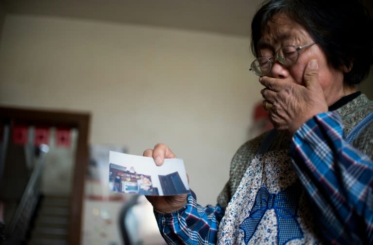 Zhang Yufang, 69, holds a photo of her late son, who died aged just 33, leaving her reliant on support from her daughter-in-law