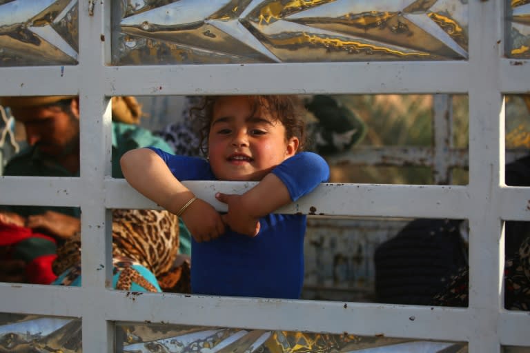 Displaced civilians are seen on the back of a pick-up truck after being rescued by members of the US-backed Syrian Democratic Forces, through a water corridor at Lake Assad, on April 29, 2017