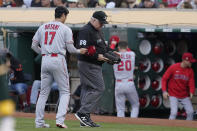 Umpire Bill Miller (26) inspects the glove of Los Angeles Angels pitcher Shohei Ohtani (17) during the third inning of a baseball gam against the Oakland Athletics in Oakland, Calif., Monday, July 19, 2021. (AP Photo/Jeff Chiu)