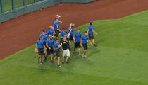 The grounds crew and security escort a fan off the field, who ran onto the field during the weather delay of game three of the College World Series Championship Series between the Arizona Wildcats and the Coastal Carolina Chanticleers on June 29, 2016 at TD Ameritrade Park in Omaha, Nebraska. (Photo by Peter Aiken/Getty Images)