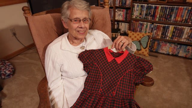 Jan Parker holds the dress worn for elementary school photos by 17 of her daughters and granddaughters. (Photo: Chad Nelson, KARE 11)