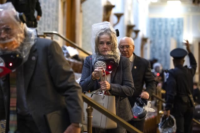 Tom Williams/CQ-Roll Call, Inc via Getty Images Lawmakers are evacuated on Jan. 6, 2021, as Donald Trump supporters breach the U.S. Capitol in an attempt to stop the 2020 election from being certified