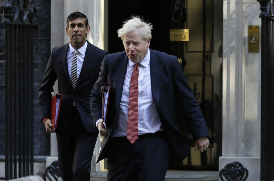 FILE - In this Tuesday, Sept. 1, 2020 file photo, Britain's Prime Minister Boris Johnson and Chancellor Rishi Sunak, left, leave Downing Street to attend a cabinet meeting in London. (AP Photo/Kirsty Wigglesworth, File)