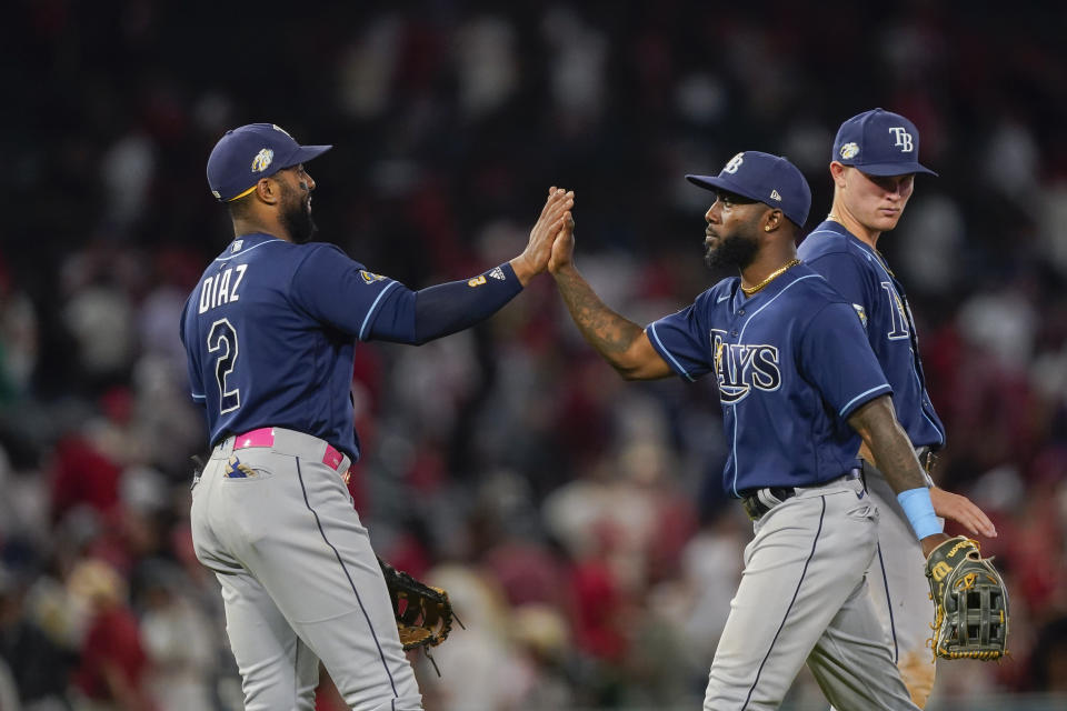 Tampa Bay Rays first baseman Yandy Diaz (2) high-fives left fielder Randy Arozarena after the team's win in 10 innings in a baseball game against the Los Angeles Angels, Friday, Aug. 18, 2023, in Anaheim, Calif. (AP Photo/Ryan Sun)