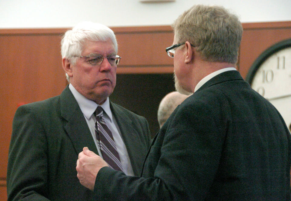 Richland County attorney Mike Weber, left, listens to Deputy County Attorney T.R. Halvorson during a break in a competency hearing in Sidney, Mont., Monday, March 24, 2014. The hearing will will decide if a Colorado man is fit for trial in the 2012 killing of a local teacher. Attorneys for defendant Michael Keith Spell say he is mentally disabled and unable to understand the case against him. (AP Photo/Matthew Brown)