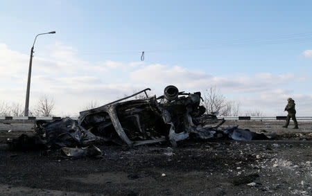 A serviceman of the breakaway Donetsk People's Republic walks near the wreckage of a minibus, which was destroyed by a landmine after swerving off road near the village of Yelenovka outside Donetsk, Ukraine February 23, 2019. REUTERS/Alexander Ermochenko